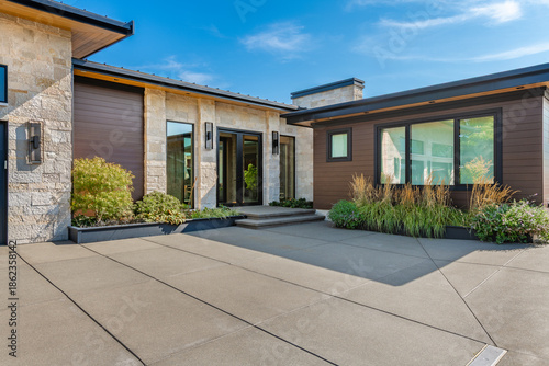 exterior private residence modern residential house architectural design flat roof garage door glass windows stone cladding outdoor kitchen grill swimming pool waterfront ocean