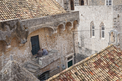 Fotografija Two tradesmen relaxing on lunchbreak on walls of Dubrovnik, Croatia
