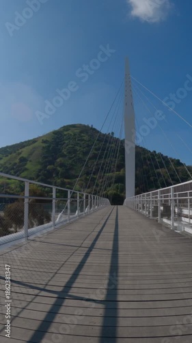 Riding across a Los Angeles river pedestrian, horse and bike bridge near Griffith Park and Glendale in Los Angeles California.  Vertical view.
