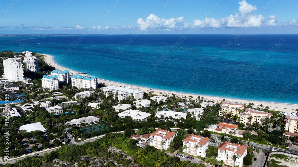 Obraz premium Grace Bay Beach At Providenciales In Overseas Territory Turks And Caicos Islands. Caribbean Beach. Tropical Scenery. Stunning Highrise Buildings. Grace Bay Beach In Turks And Caicos Islands.