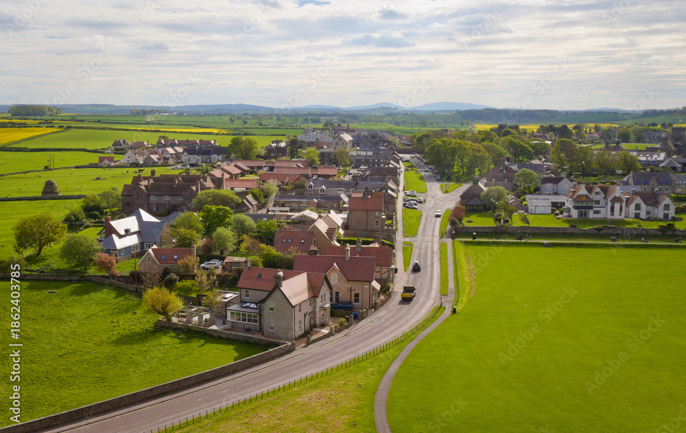 Fototapeta premium Scenic countryside village with winding road – Bamburgh Castle - England