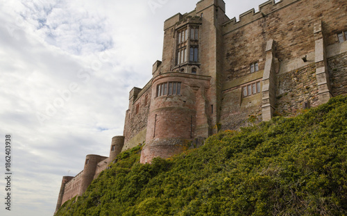 Historic stone castle on a hill under cloudy sky – Bamburgh Castle - England