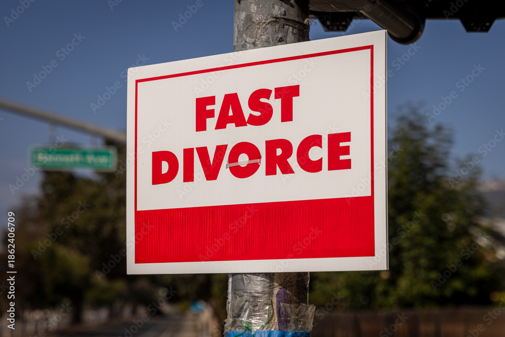 Fototapeta premium A sign stating Fast Divorce on a light pole in a suburban neighborhood