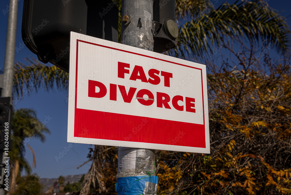 Fototapeta premium A sign stating Fast Divorce on a light pole in a suburban neighborhood
