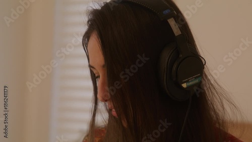 Woman puts on retro headphones and starts playing music on cassette player - close up