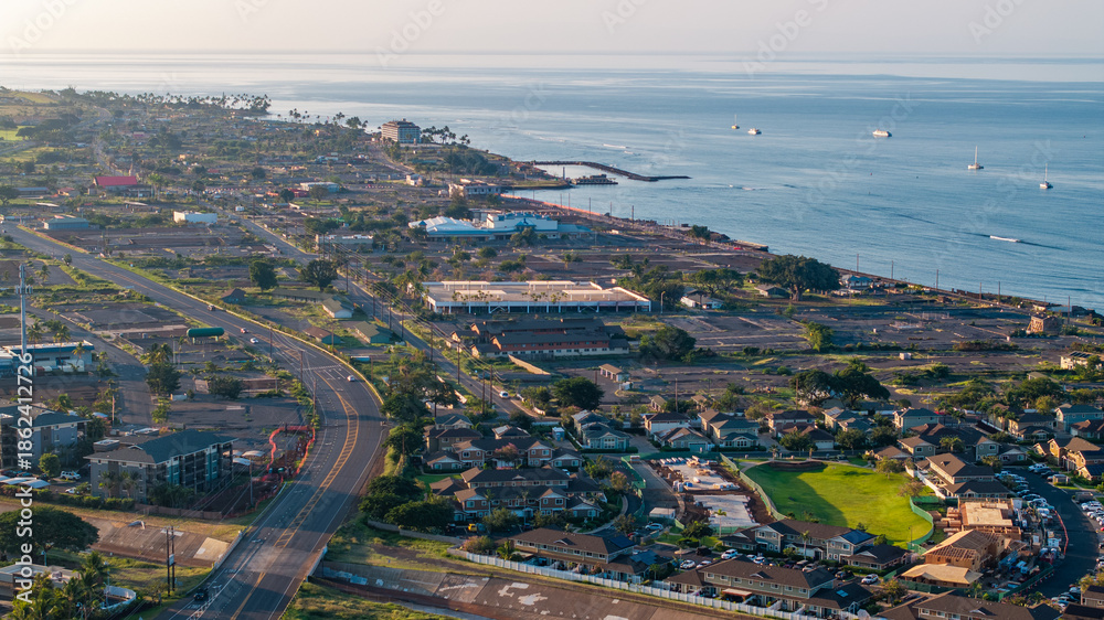 Fototapeta premium Aerial view of Lahaina landscape in Maui, Hawaii wildfire aftermath showing coastline, roads, homes, and ocean during morning light
