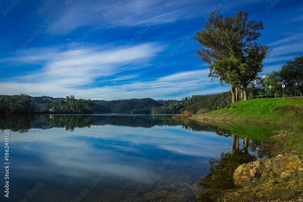 Fototapeta premium Tranquil Landscape with reflective waters of the Zêzere River in Central Portugal in the river beach of Alqueidao - Tomar