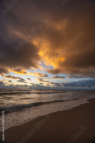 Vertical Dramatic Sunrise Over Ocean Waves With Golden Clouds