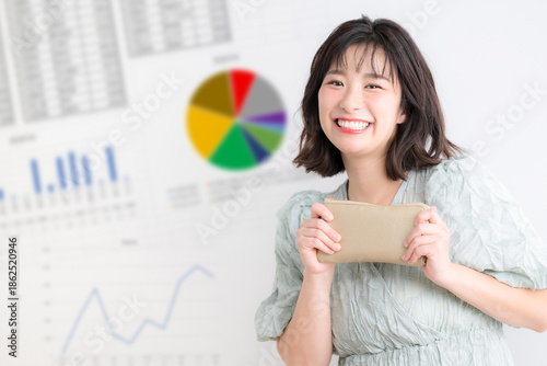 Foto NISAやiDeCoで積み立て投資を考える女性、家計管理と資産運用を示す投資グラフ背景　カメラ目線笑顔