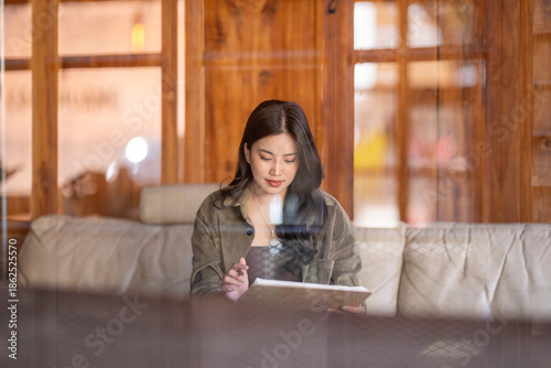 Asian woman writing notes in a cafe