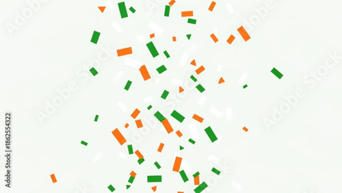 Colorful confetti pieces in orange and green falling against a light green background with white spots with party and celebration and festival