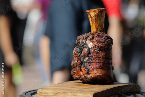 Tableau sur toile Roasted beef knuckle on a wooden table outside on a sunny day
