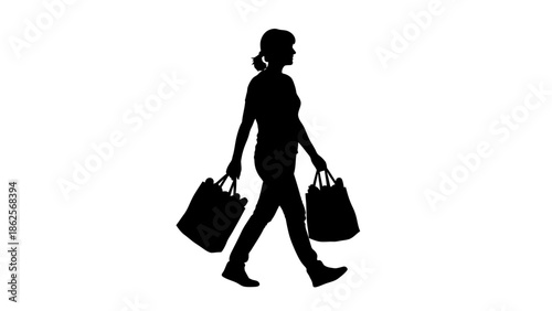 Silhouette of a woman walking briskly while carrying two heavily laden reusable shopping bags full of groceries or purchases against a bright white background