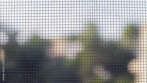 View of trees and sky through a wire mesh screen