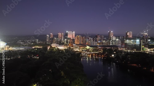 Adelaide City, South Australia in Evening– Aerial Drone View of Night Skyline, Towers, Riverbank Precinct, Festival Lights, Urban Cityscape Along River Torrens