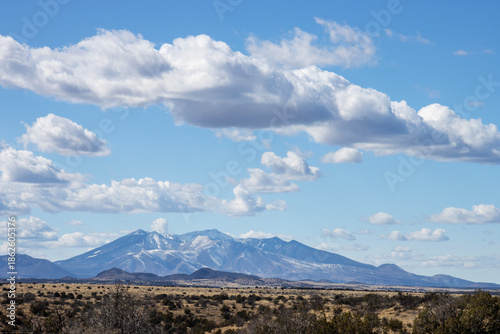 Snow-capped San Francisco Peaks under spectacular clouds near Flagstaff, Arizona, as seen from across the prairie near I-40