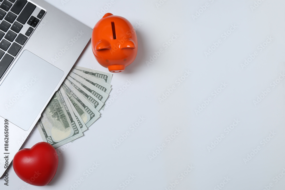 Fototapeta premium Piggy bank, money on the table, top view. 