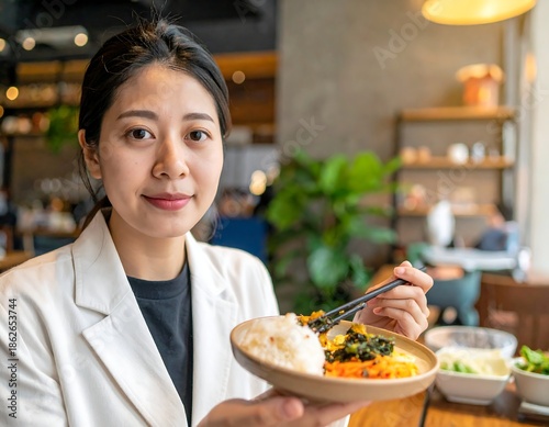 Asian woman smiling while holding a plate of food