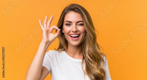 Woman Winking Making Ok Gesture Over Orange Background