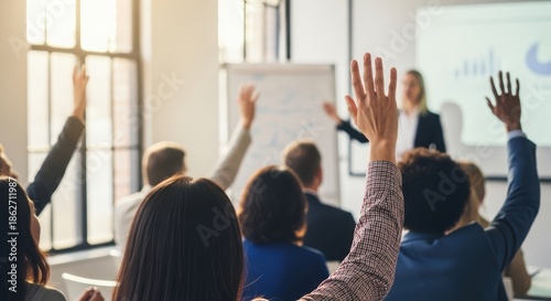 Diverse audience raising hands during business seminar