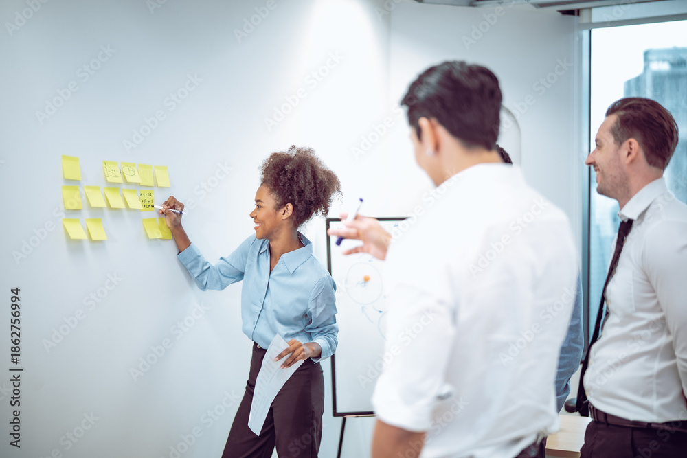 Fototapeta premium Colleagues engage in a productive business discussion, using visual tools to support planning and decision making. Teamwork, diversity, leadership, and strategic collaboration work.