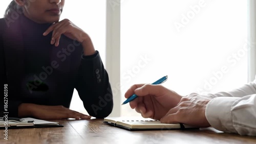 Wallpaper Mural Close up of two business people in meeting, one woman talking and gesturing while man takes note on notebook at desk Torontodigital.ca