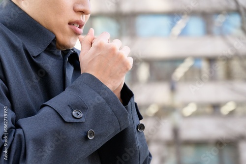 Fotografia 冬のオフィス街で寒そうな日本人男性