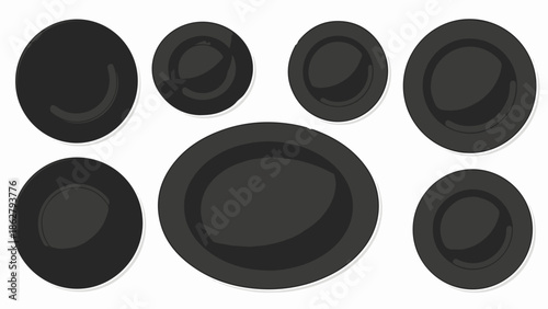 A collection of dark, circular and oval plates are arranged symmetrically