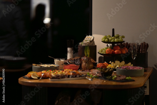 Gourmet buffet table featuring elegant appetizers and charcuterie, set for a corporate or private celebration. Catering buffet with fresh fruit and waxed amaryllis bulb displayed for a premium event. 