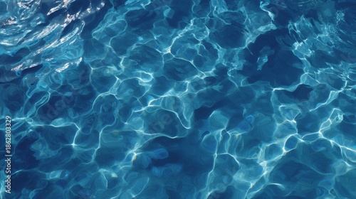 Overhead shot of shimmering pool water ripples with vibrant blue highlights and reflective textures under bright sunlight, creating a calming and refreshing aquatic pattern with ample space for copy