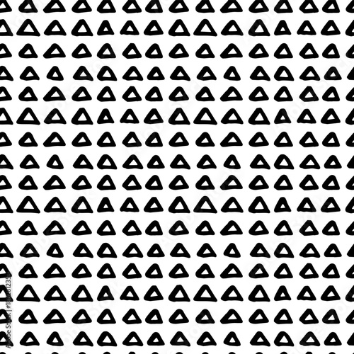 Geometric pattern showcasing hand-drawn triangular elements. Seamless doodle design with abstract rough brush textures, and simple black shapes for modern textiles.