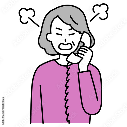 固定電話で怒っている年配の女性