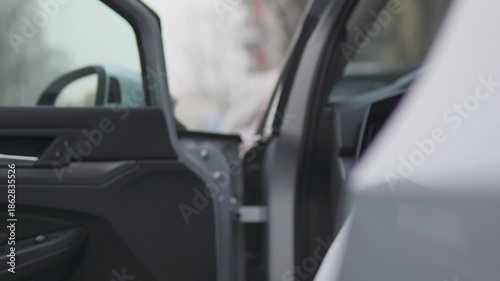 A man opens a car door, gets into the car, and closes the door - focused closeup on the handle