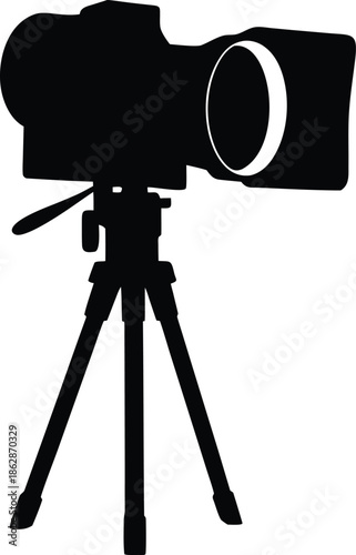 High quality digital camera silhouette positioned on a stable tripod for photography