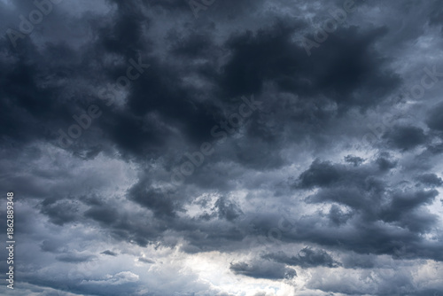 Billede på lærred Dense dark storm clouds fill the overcast sky with a soft light glowing from below