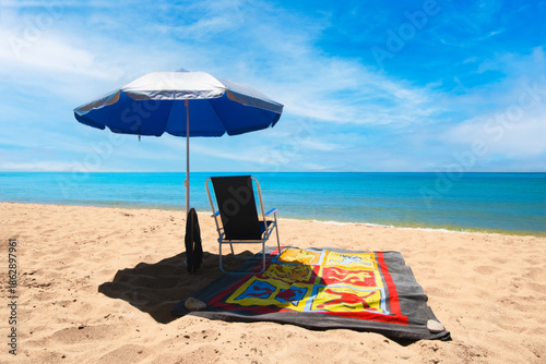 Canvas Print Colorful beach towel on sunbed with chair and umbrella on sandy beach in Corfu, Greece