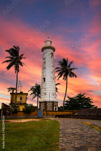 Slika na platnu Galle Lighthouse in Sri Lanka stands tall against a vibrant sunset sky, showcasi