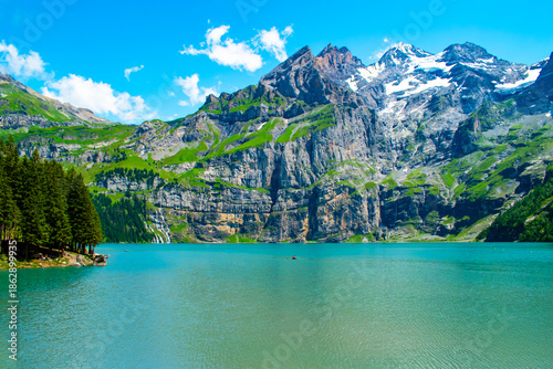 Slika na platnu Oeschinen Lake, Switzerland, is a crystal-clear alpine lake surrounded by towering mountains and lush meadows