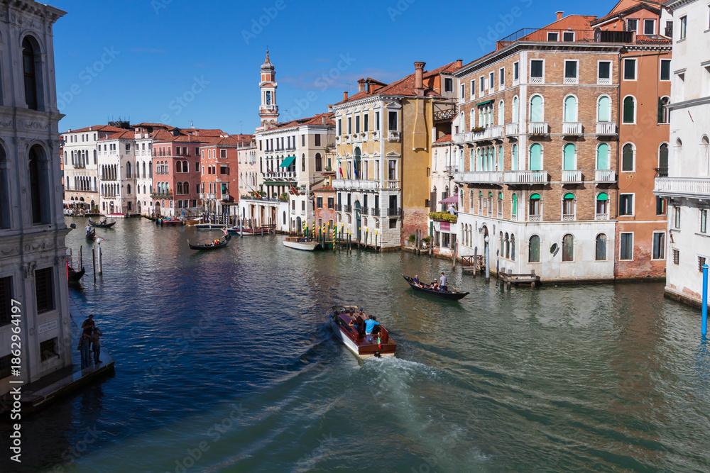 Obraz premium Canal Grande w Wenecji, historyczne kolorowe kamienice nad kanałem i łódź, Włochy