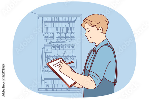 Man inspector checks electrical equipment installed in metal power panel, makes notes in clipboard. Electrician guy stands near power panel, drawing up work plan for replacing wires.