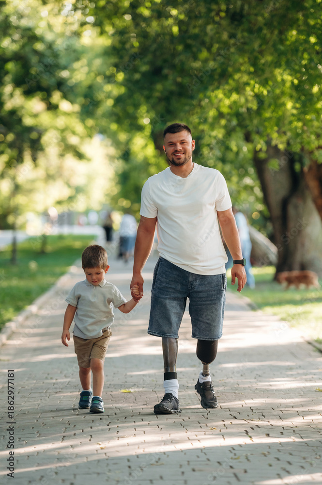 Obraz premium Father that is amputee with prosthesis is with his little son in the park