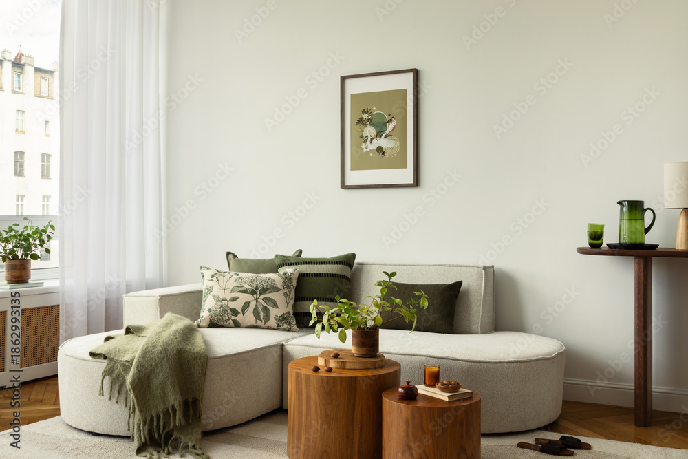 Obraz premium Living room with a bright corner sofa, round wooden tables, green accents, and soft textiles, styled with plants and glassware.