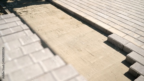 Tableau sur toile Laying gray interlocking brick pavers on a prepared sand base, creating a durabl