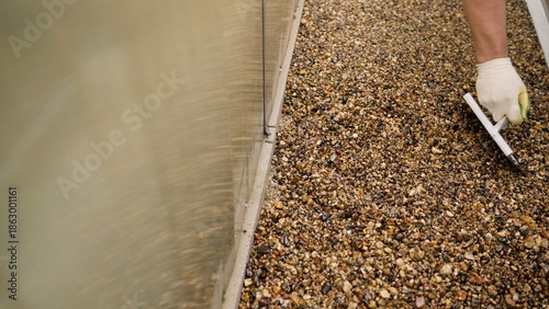 Fotografi Worker applying resin bound gravel surface by hand