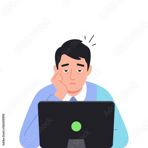 Young man looking bored while working on laptop at desk  