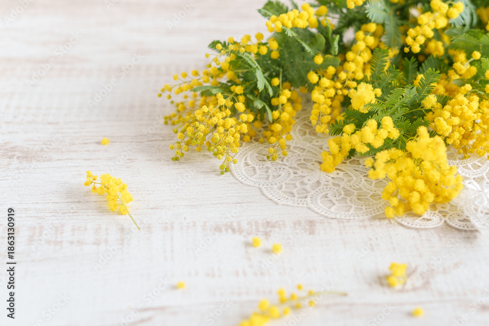 Fototapeta premium テーブルに置かれたミモザの花とレース