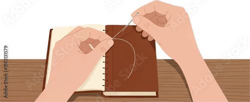 Hands stitching a book on a wooden surface
