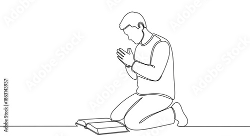 Man kneeling in prayer with hands clasped beside open book  