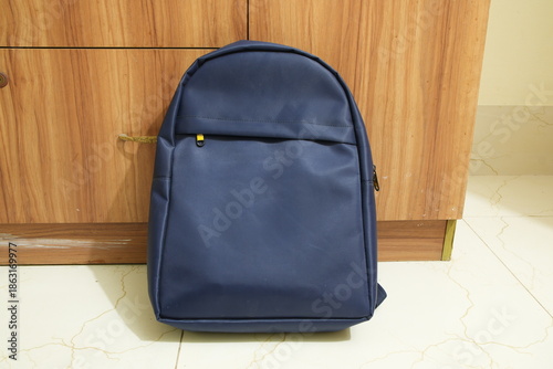 Navy Blue Minimalist Backpack Against Wooden Cabinet