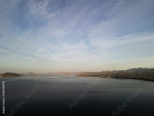 Aerial panoramic shot of foggy mountain valley during morning golden hour.